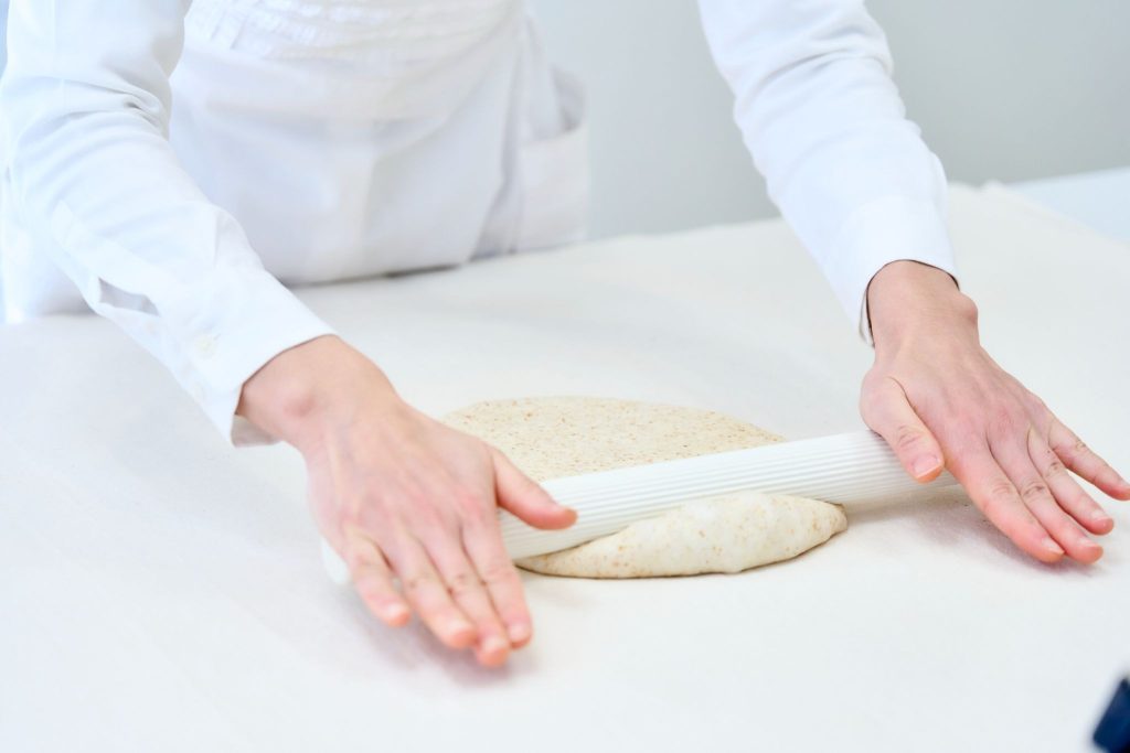 パン作りの一次発酵後に行う生地のガス抜きとパンチ工程の手元