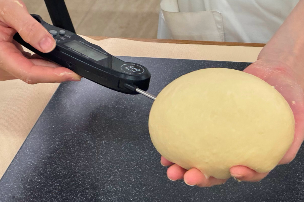 パンの発酵しすぎを防ぐため温度計で室温や仕込み水の温度を精密に計測して管理する様子